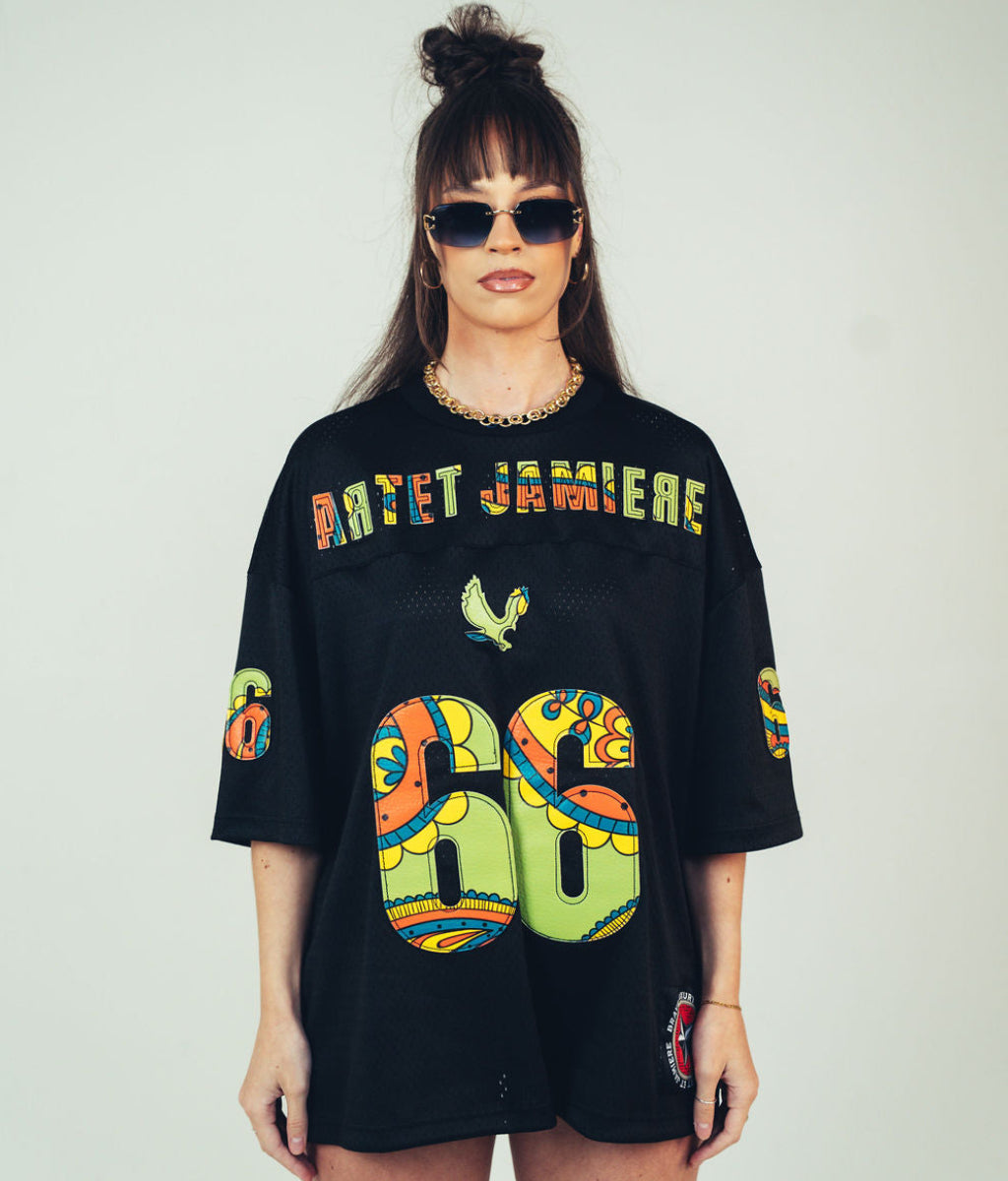 Person wearing a black oversized t-shirt with colorful graphics and text.