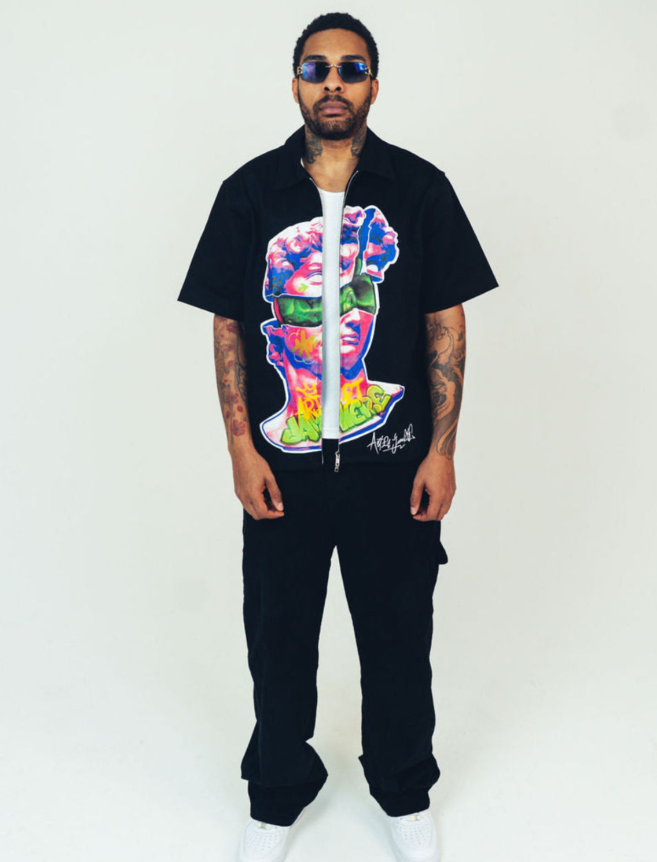 Person wearing a black outfit with a colorful graphic design on a white background