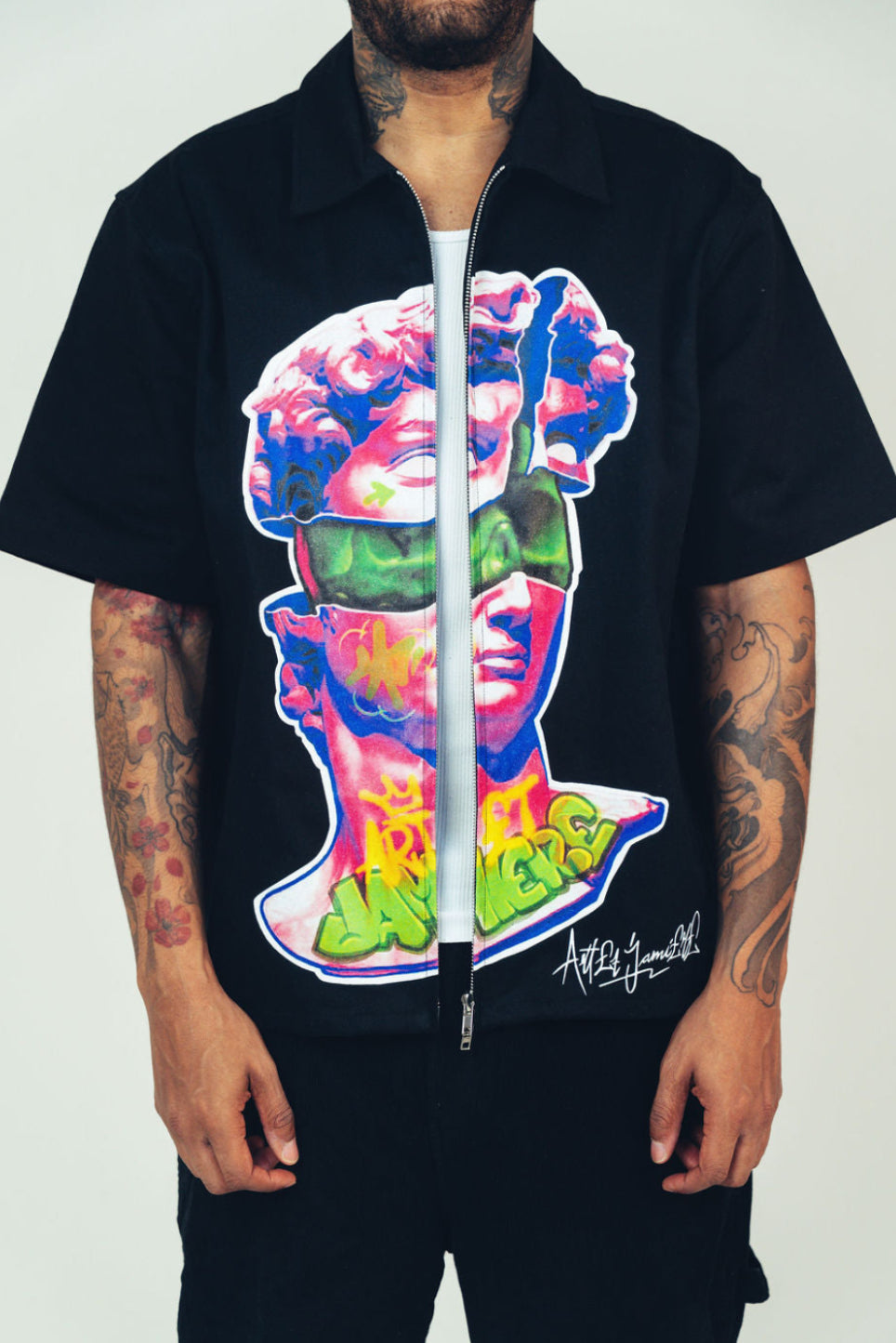 Person wearing a black jacket with a colorful graphic design on a white background